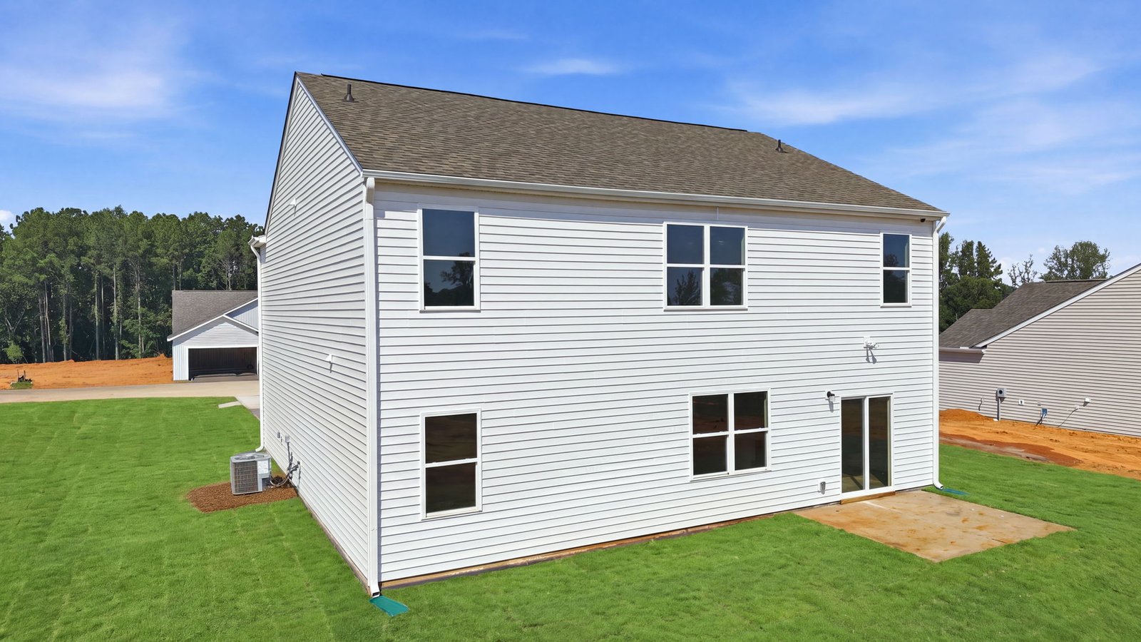 rear view of two story home with back yard and back patio pad