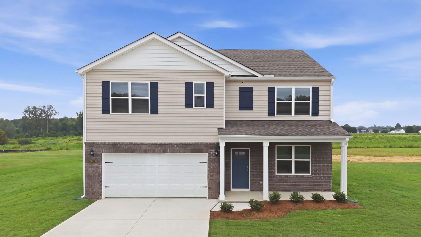 exterior of two story home with brick and vinyl and two car garage