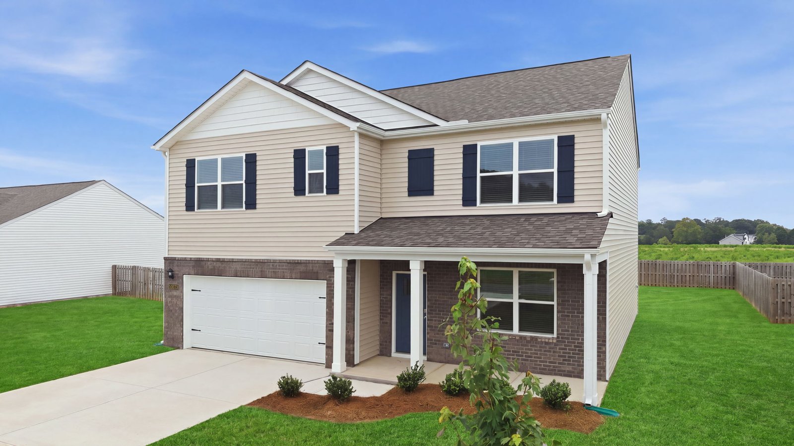 exterior of two story home with brick and vinyl and two car garage