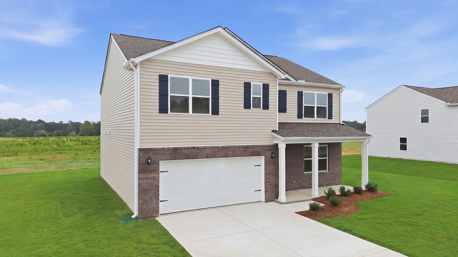 exterior of two story home with brick and vinyl and two car garage