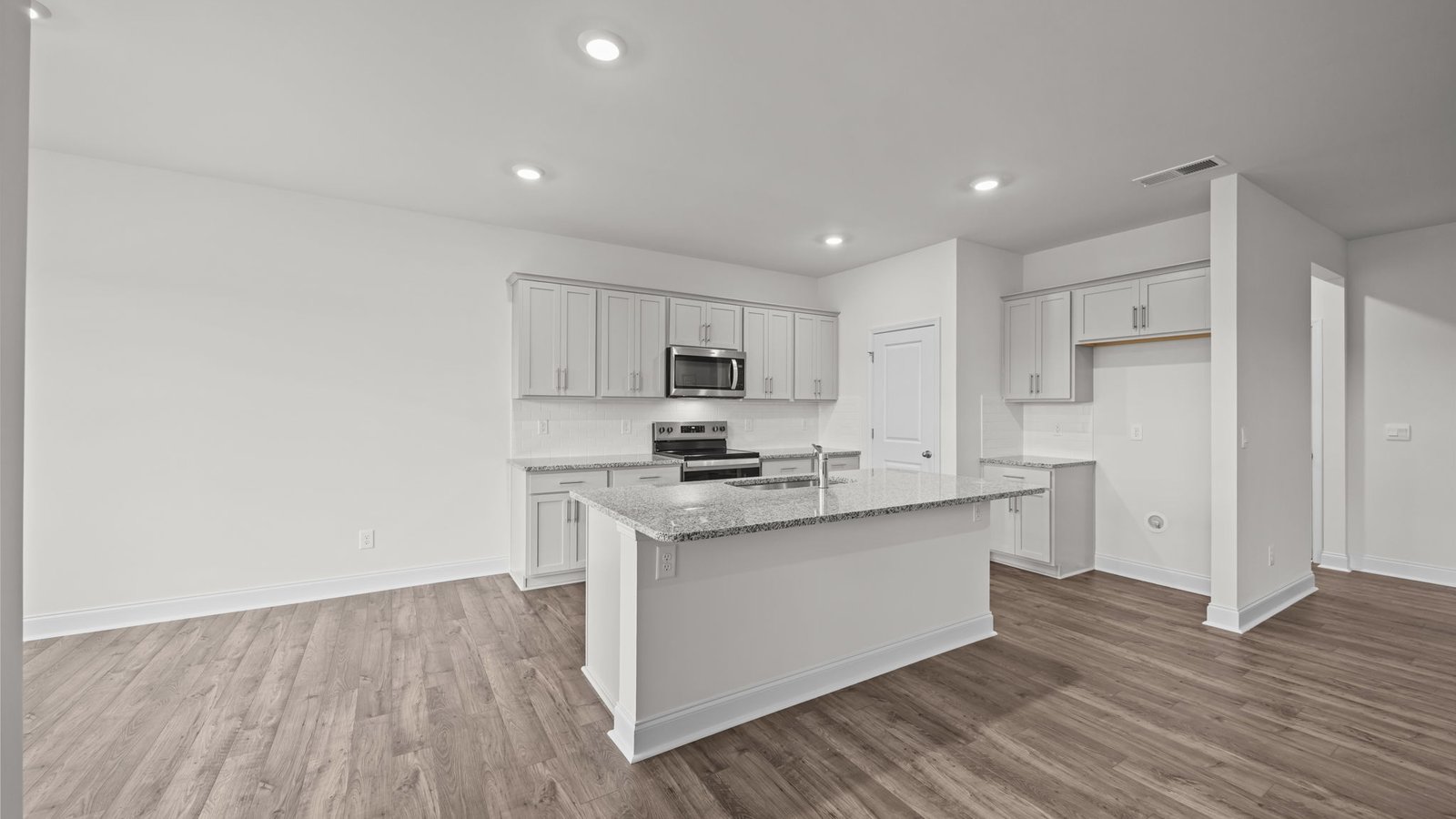 Kitchen area with white cabinets and stainless steel appliances