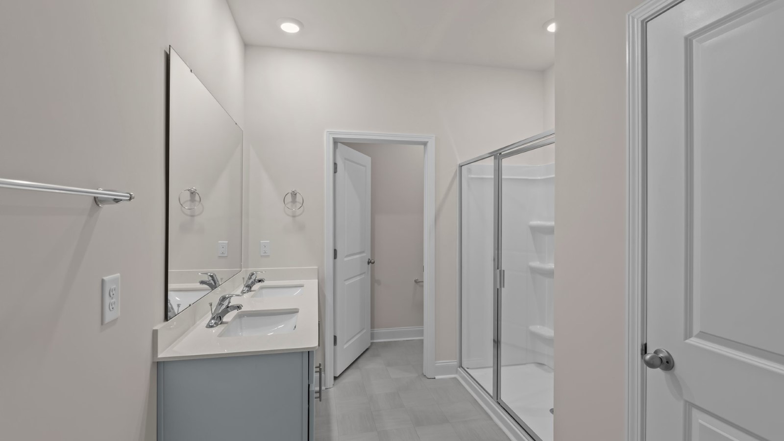 primary bath with double sinks and grey cabinets