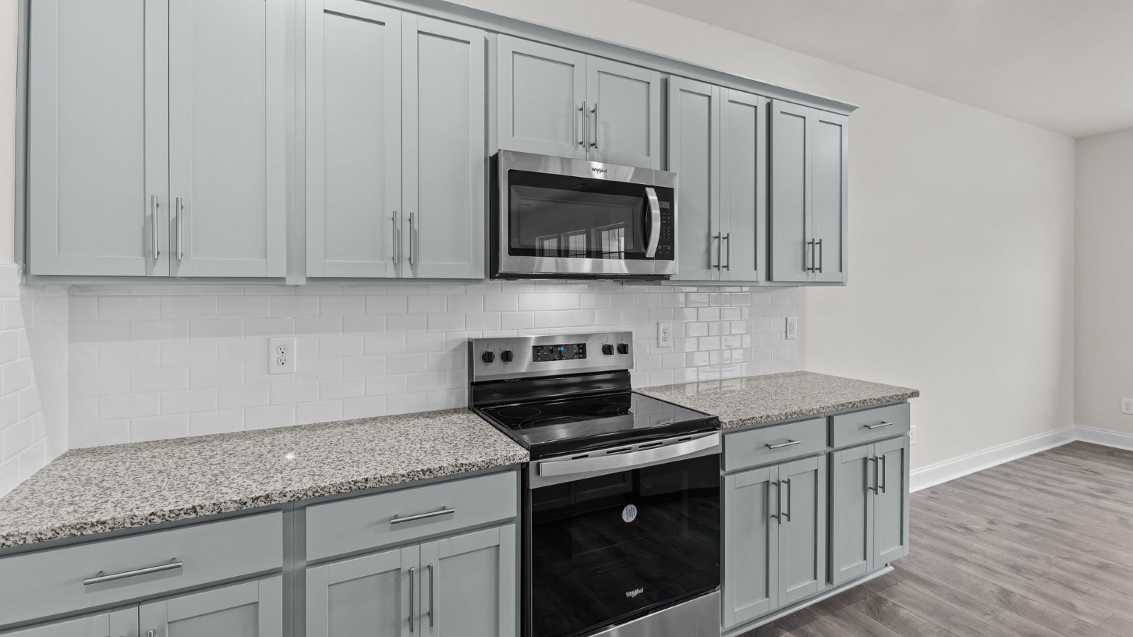 kitchen area with grey cabinets and stainless steel appliances