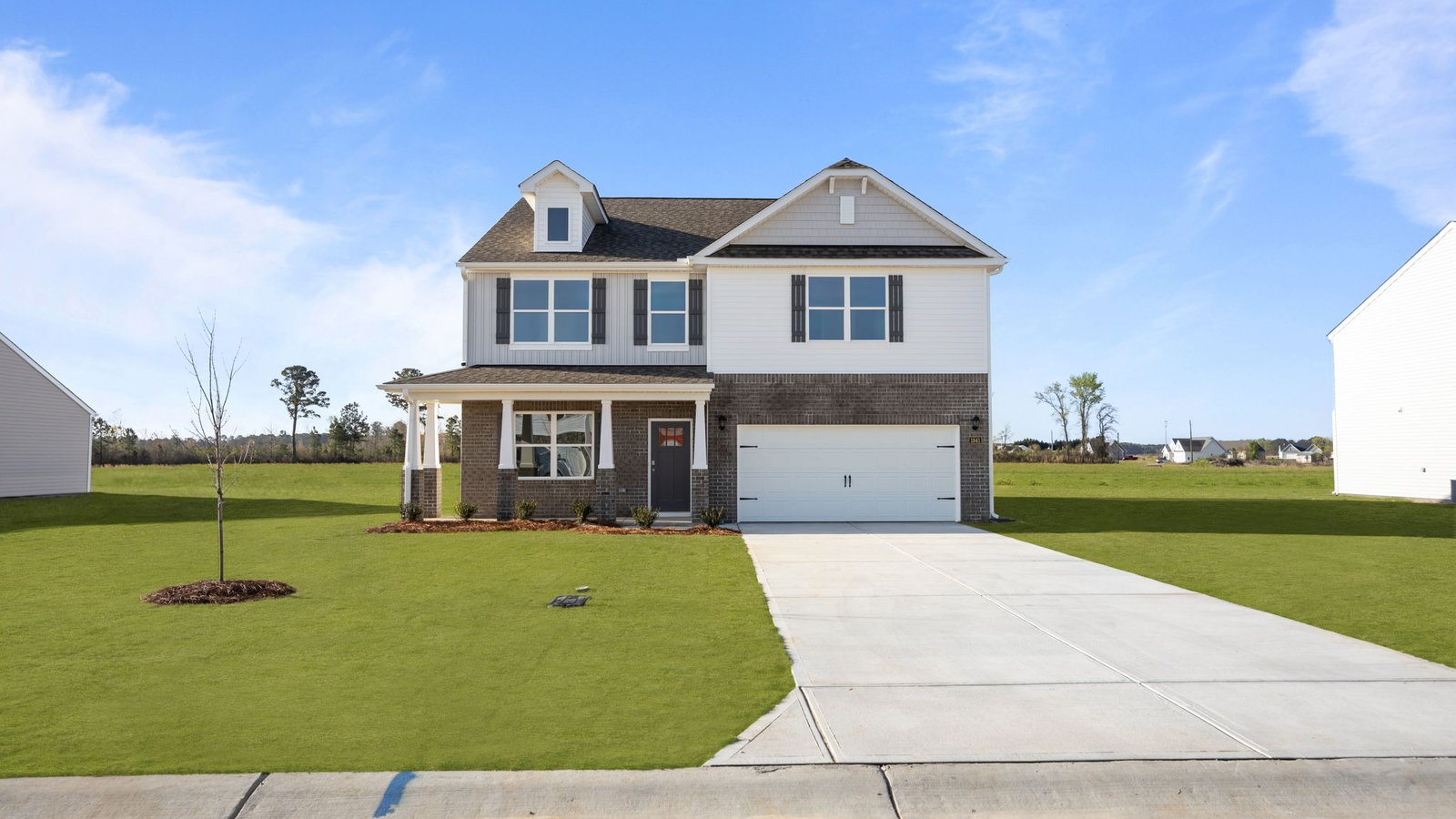 exterior of two story home with brick and vinyl and two car garage