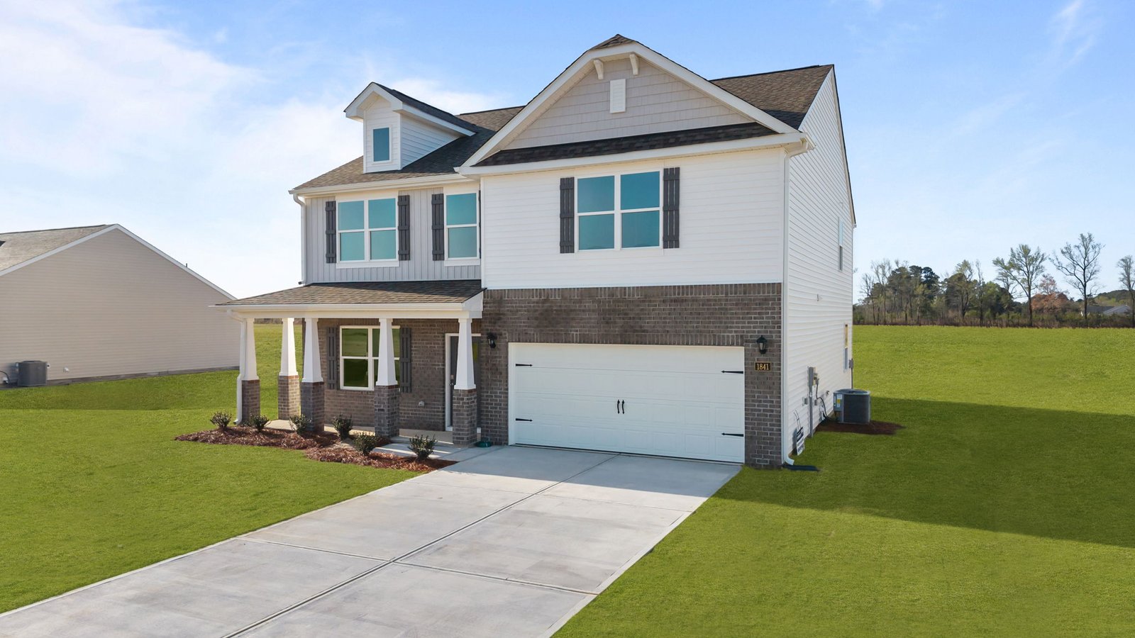 exterior of two story home with brick and vinyl with two car garage