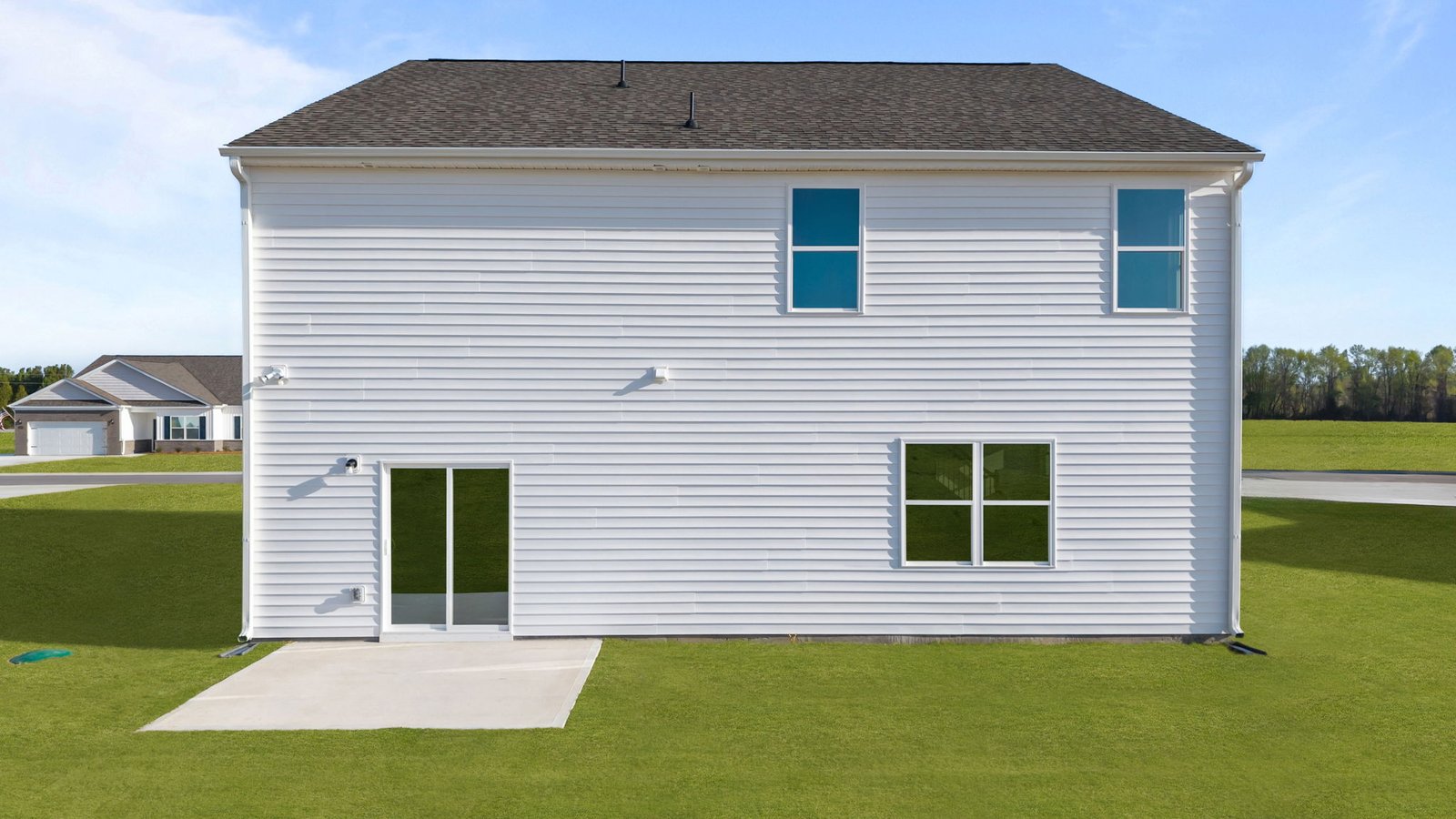 back of two story home with back patio pad