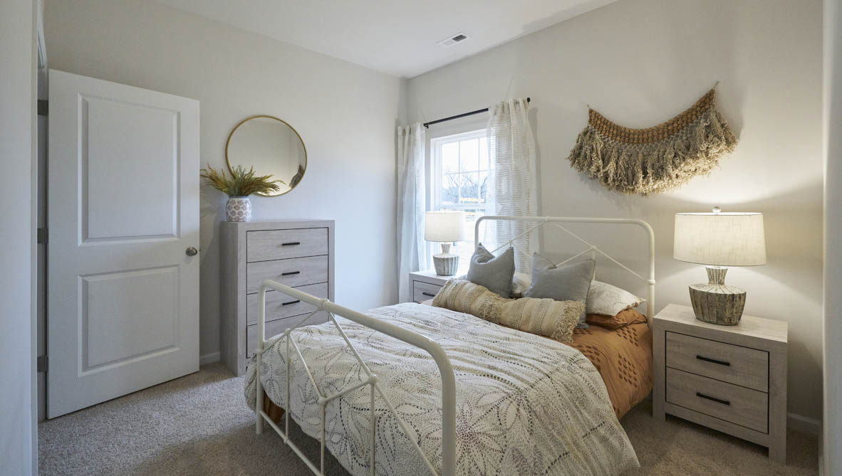 bedroom with beige carpet, white walls and a window