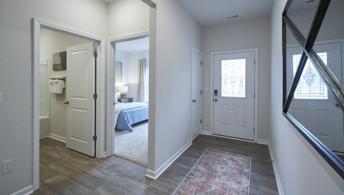 front entry way of home featuring brown flooring and white walls