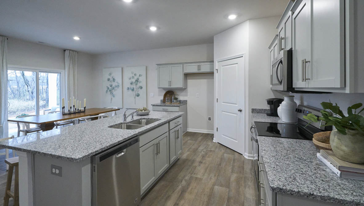 kitchen with light grey cabinetry, large island and stainless steel appliances