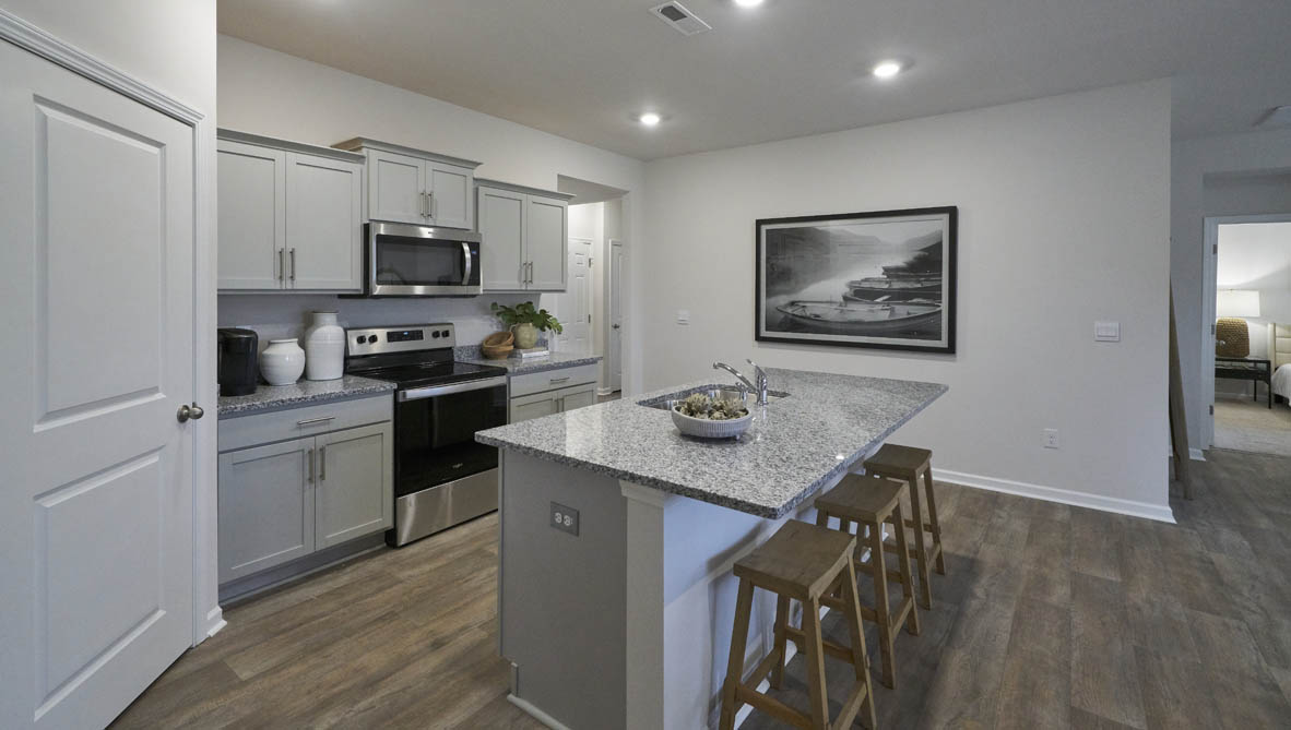kitchen with light grey cabinetry, large island and stainless steel appliances
