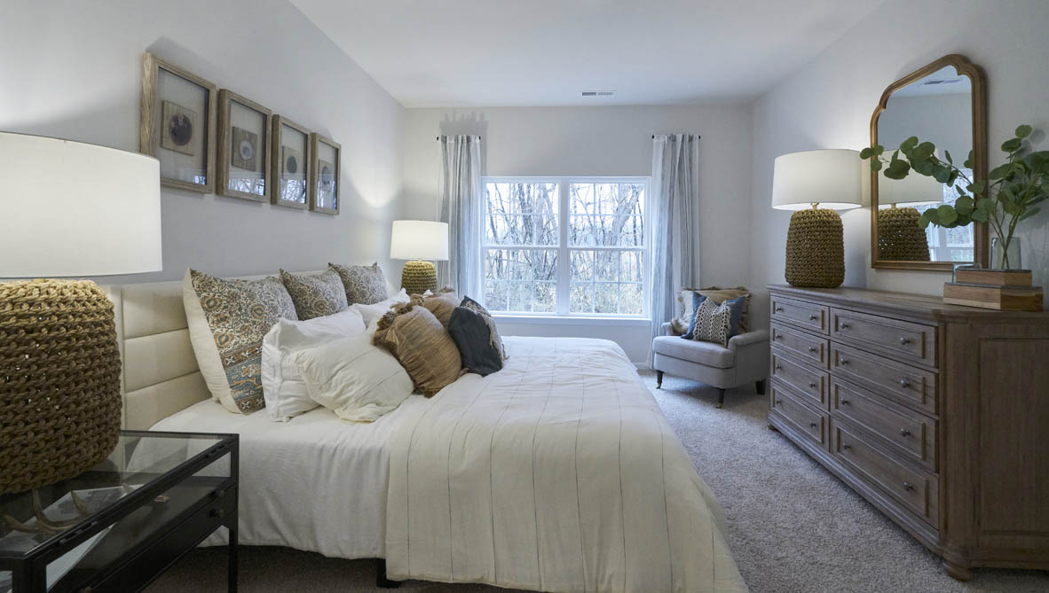 bedroom with beige carpet, white walls and a window