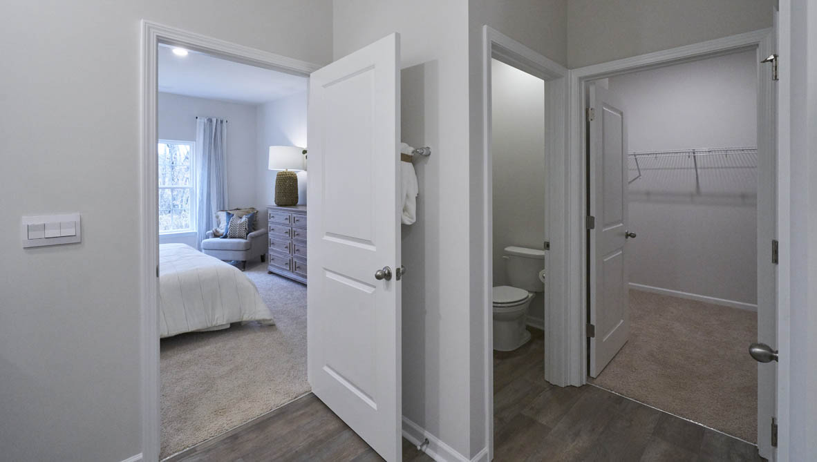 bathroom with dual vanity sinks, toilet, and a walk in shower