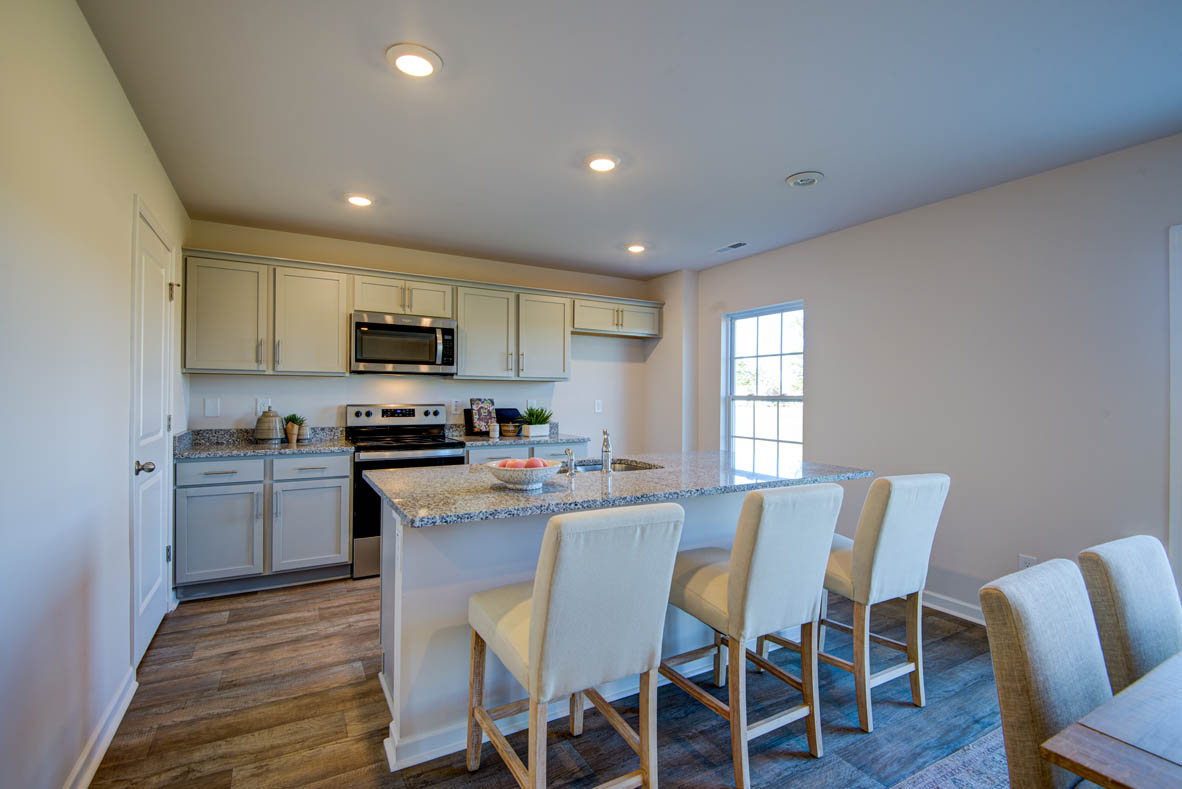 kitchen with light grey cabinetry, large island and stainless steel appliances