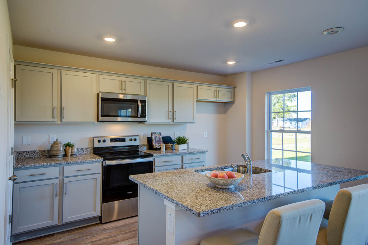 kitchen with light grey cabinetry, large island and stainless steel appliances