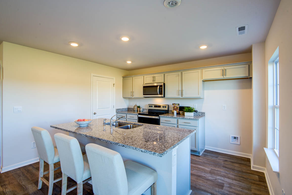 kitchen with light grey cabinetry, large island and stainless steel appliances