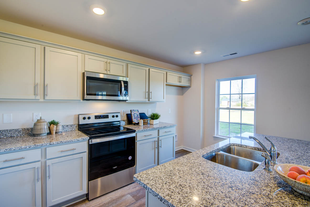 kitchen with light grey cabinetry, large island and stainless steel appliances