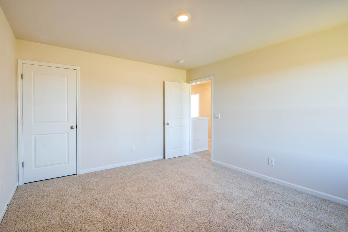 bedroom with beige carpet, beige walls and a window