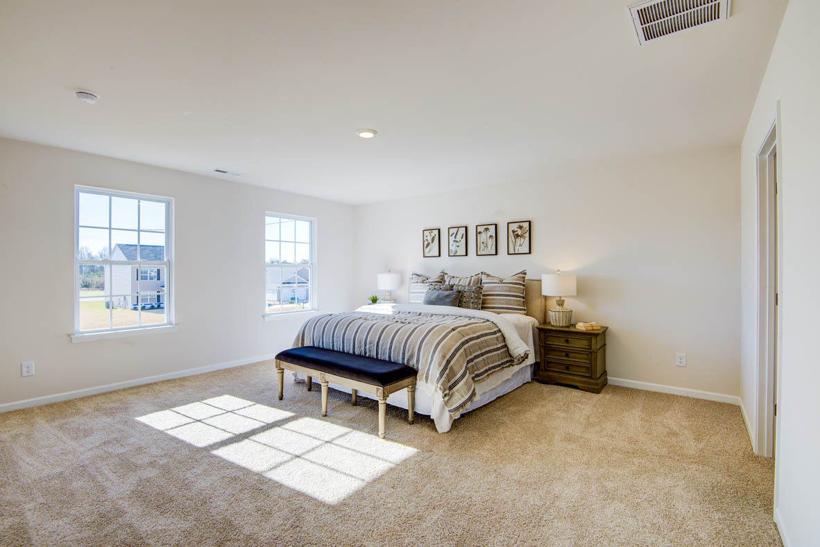 bedroom with beige carpet, beige walls and a window
