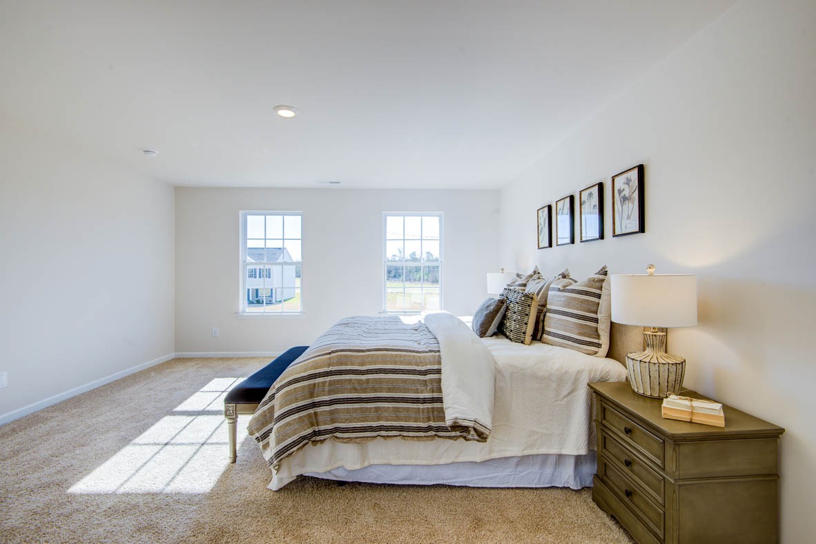 bedroom with beige carpet, beige walls and a window