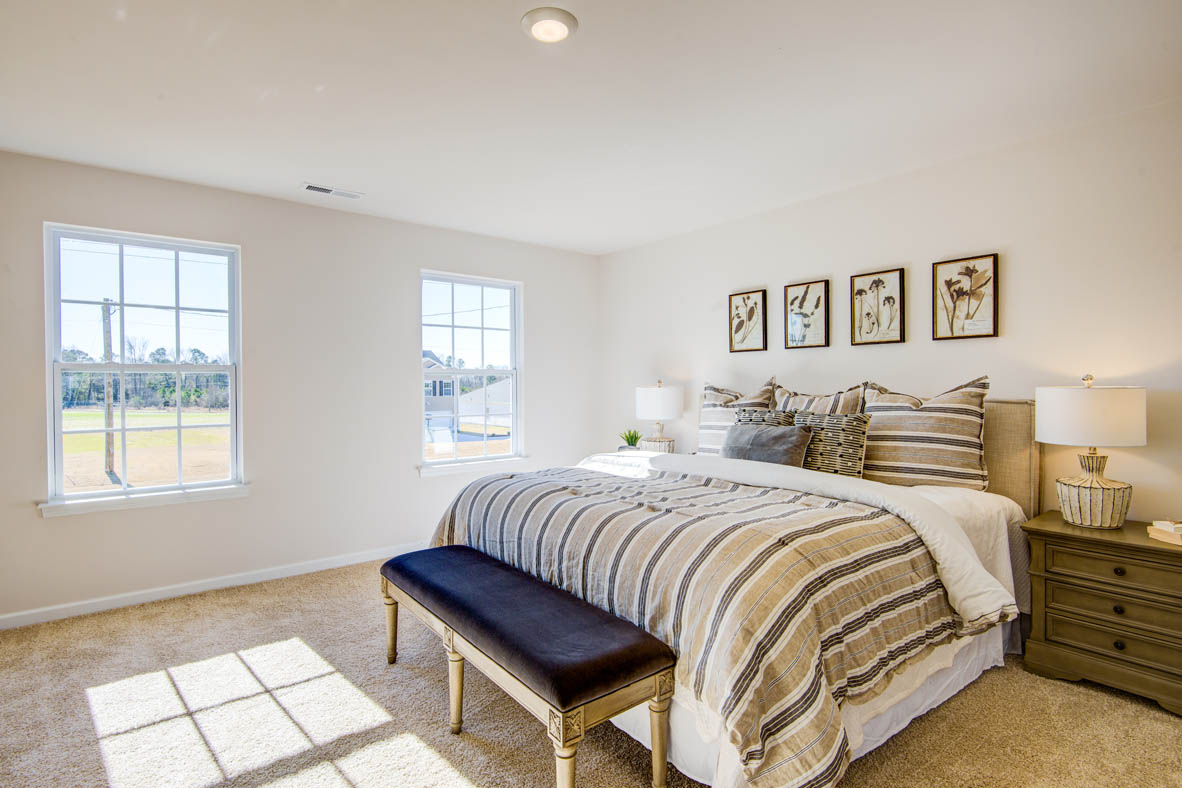 bedroom with beige carpet, beige walls and a window