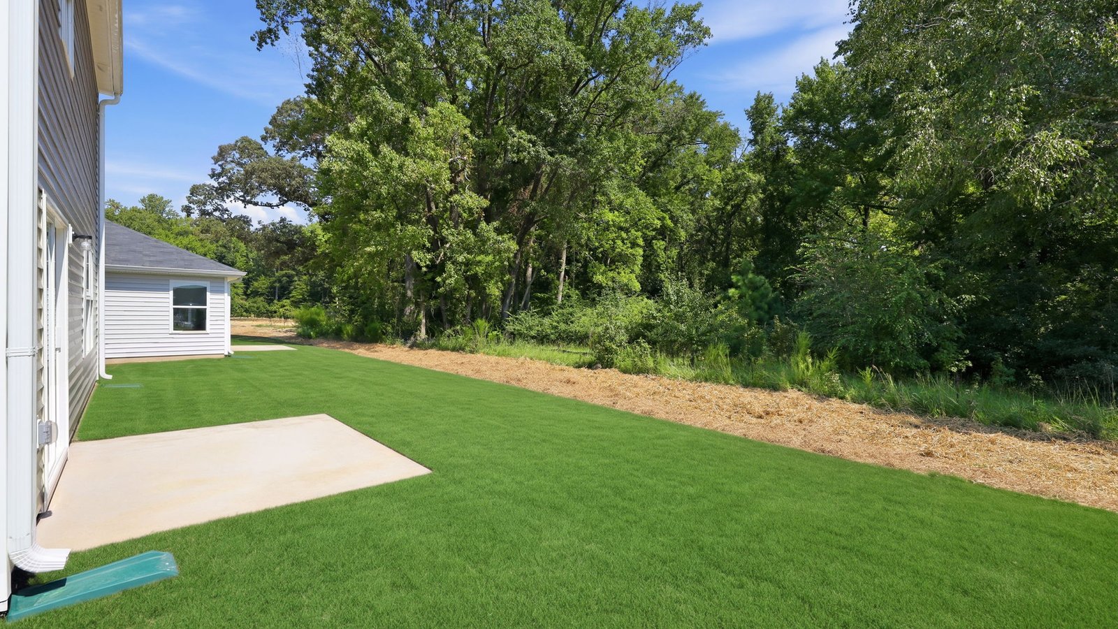 rear view of back yard lot and back patio pad