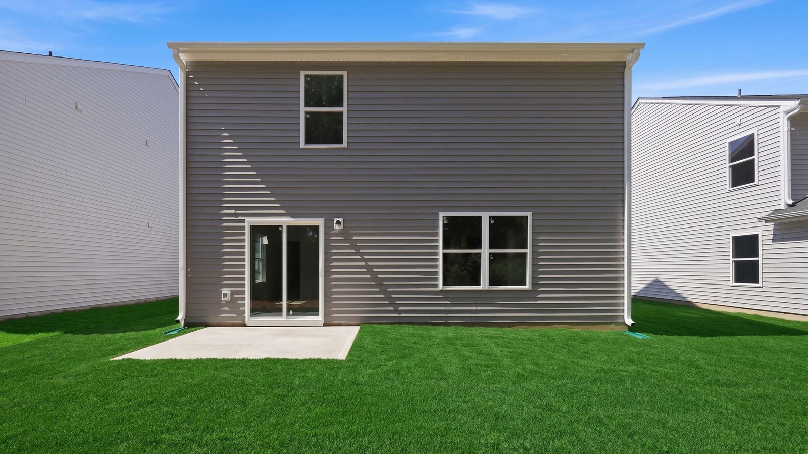 rear view of two story home with back yard