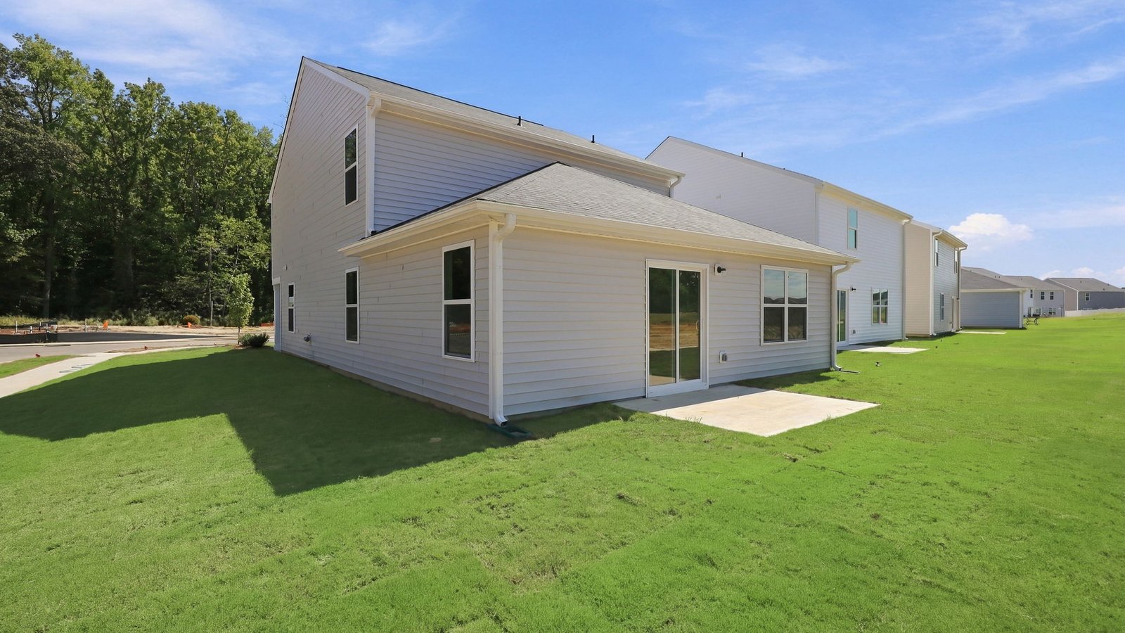 rear view of home and lot and back patio pad