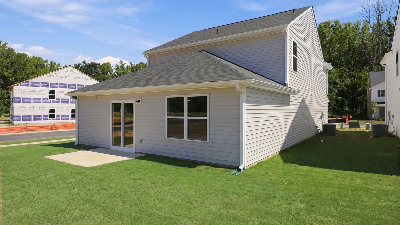 rear view of the two story home and back patio pad