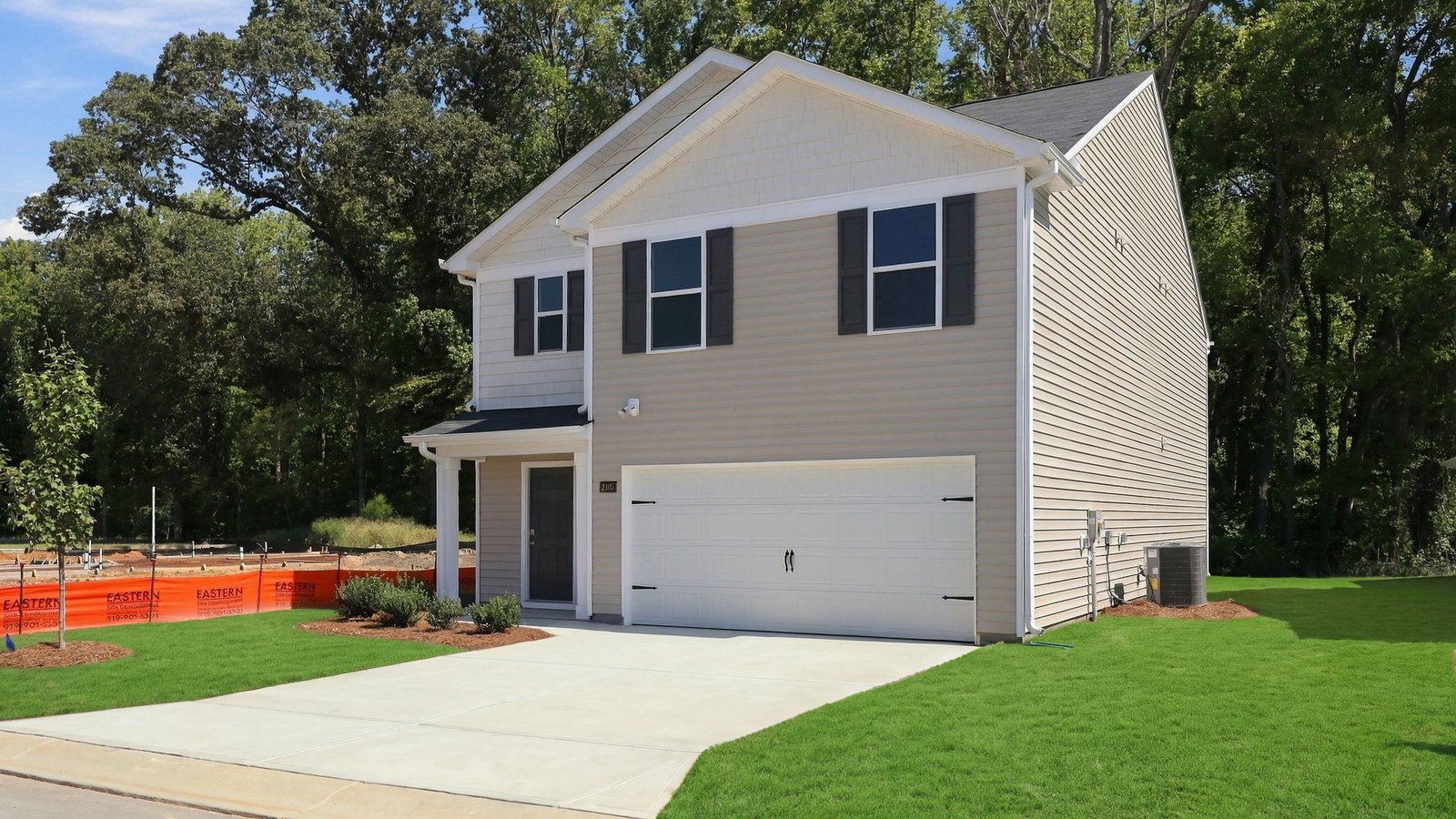 front of the two story family home with driveway and two car garage