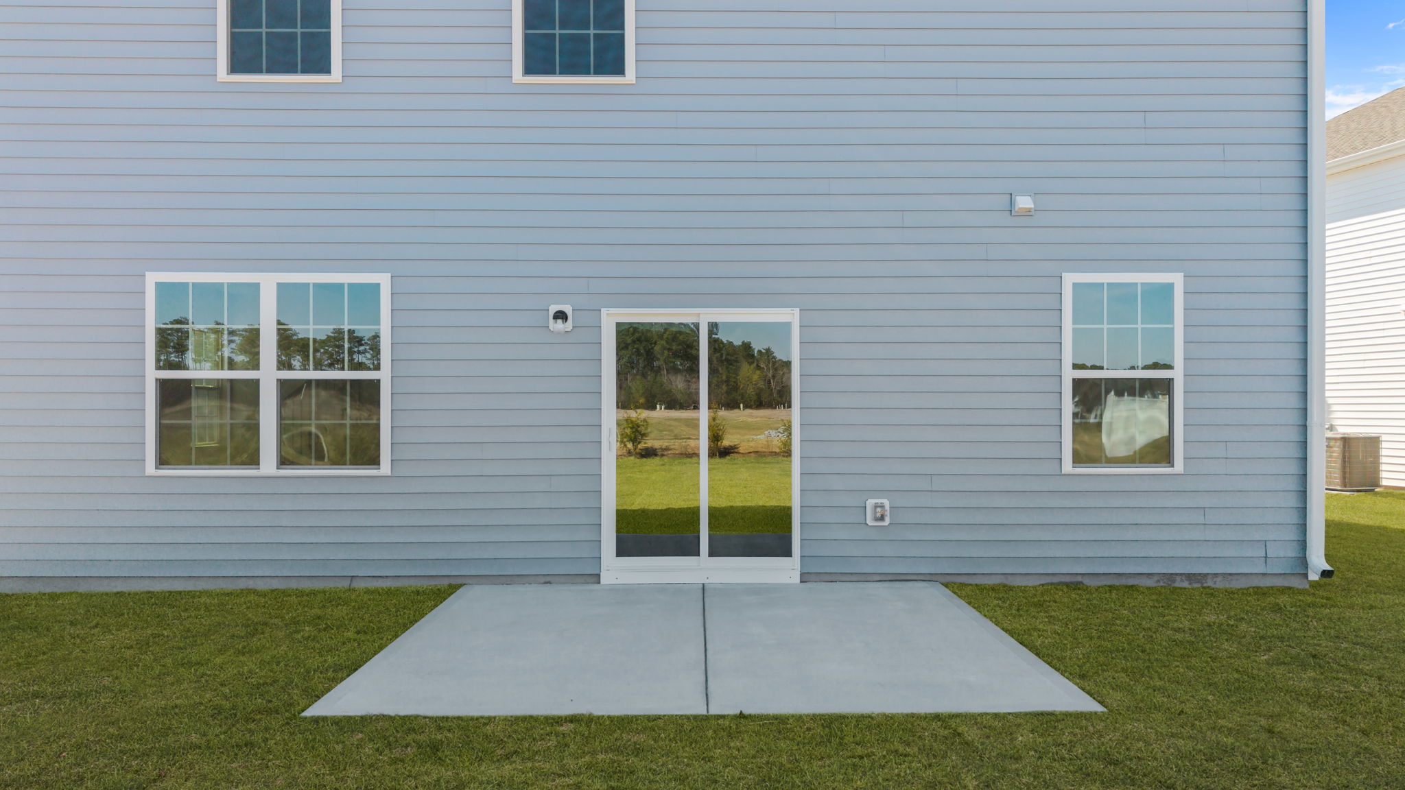 Sliding back glass door from kitchen area leading out on the back patio pad