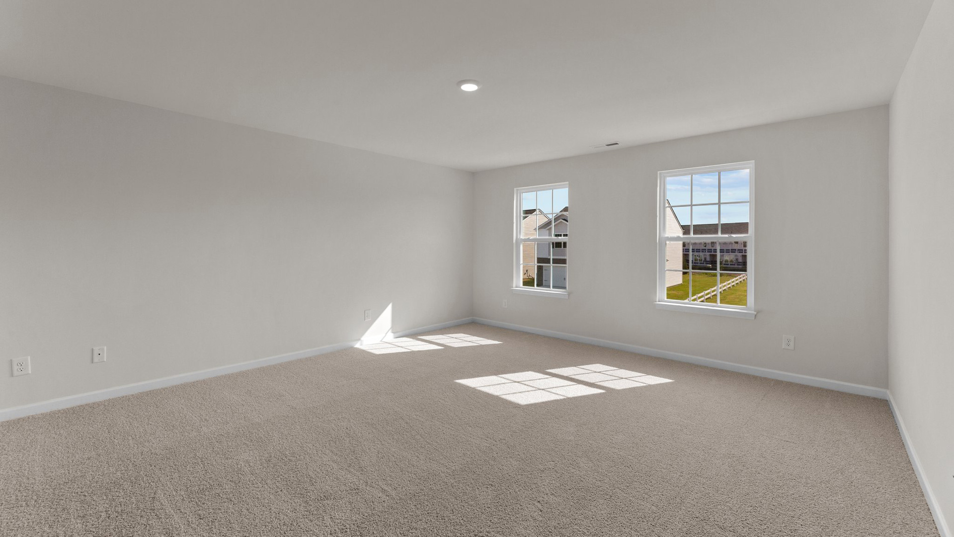 bedroom with beige carpet, white walls and a window