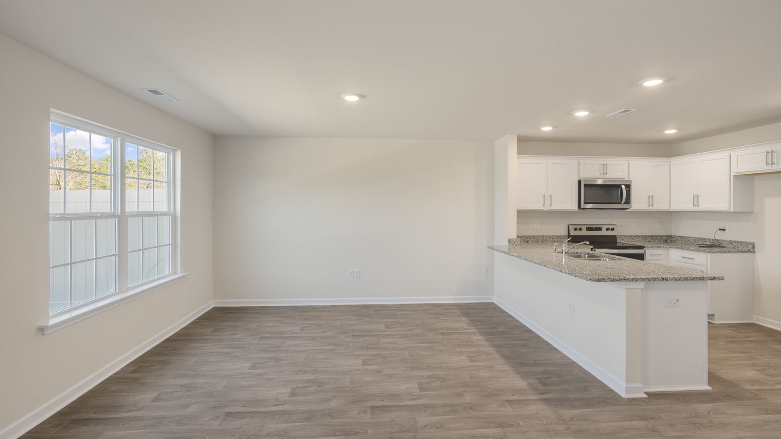 kitchen with white cabinetry, large island, and stainless steel appliances