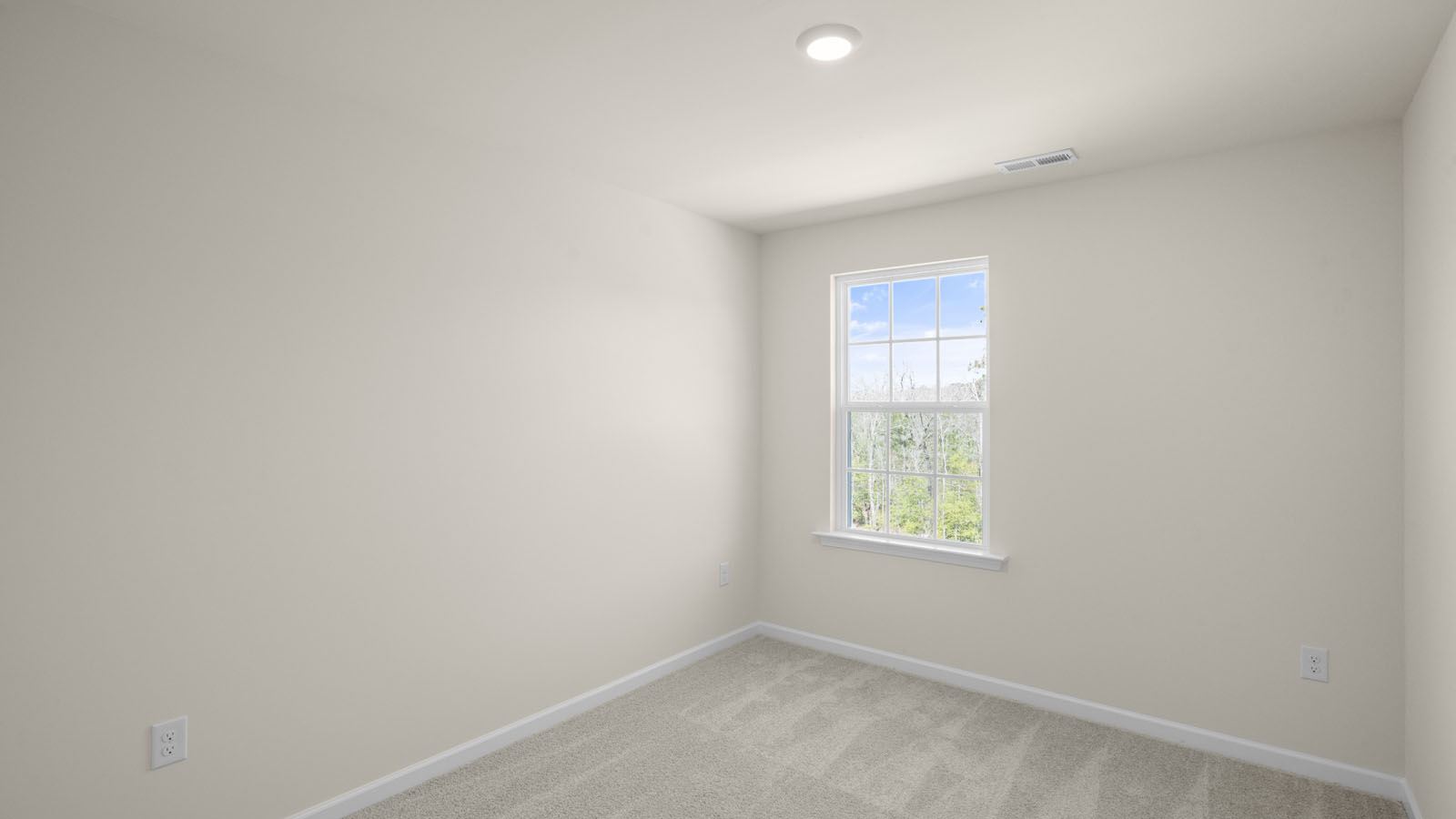 bedroom with beige carpet, beige walls and a window