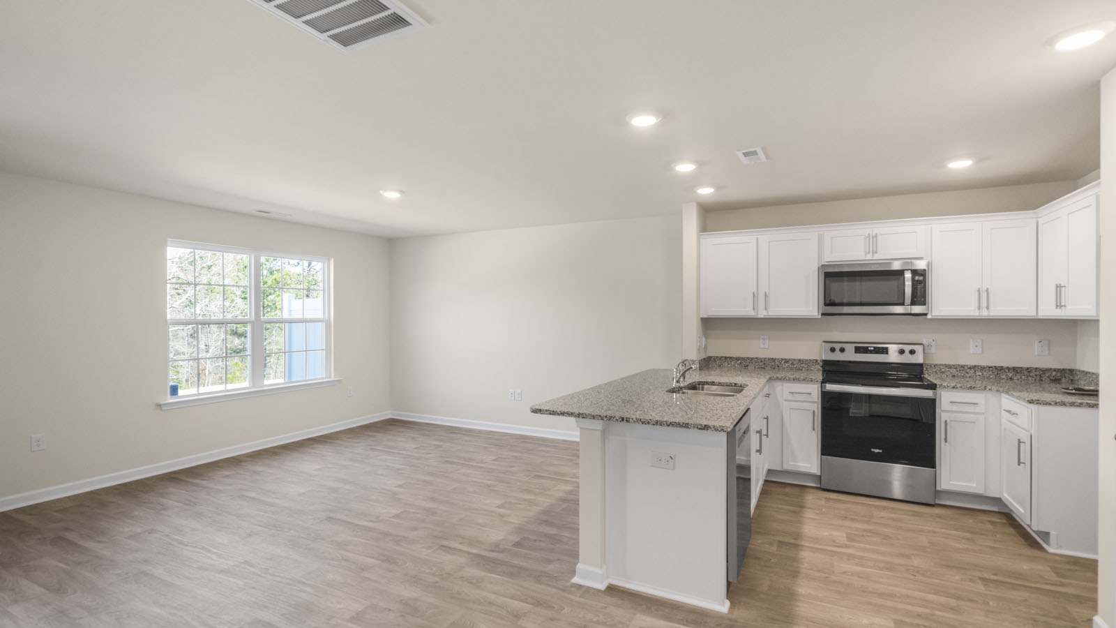 kitchen with white cabinetry, large island, and stainless steel appliances