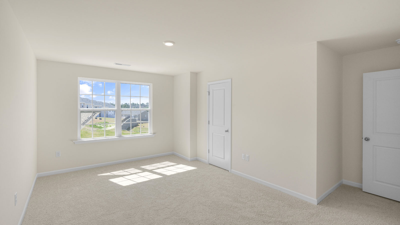 bedroom with beige carpet, beige walls and a window