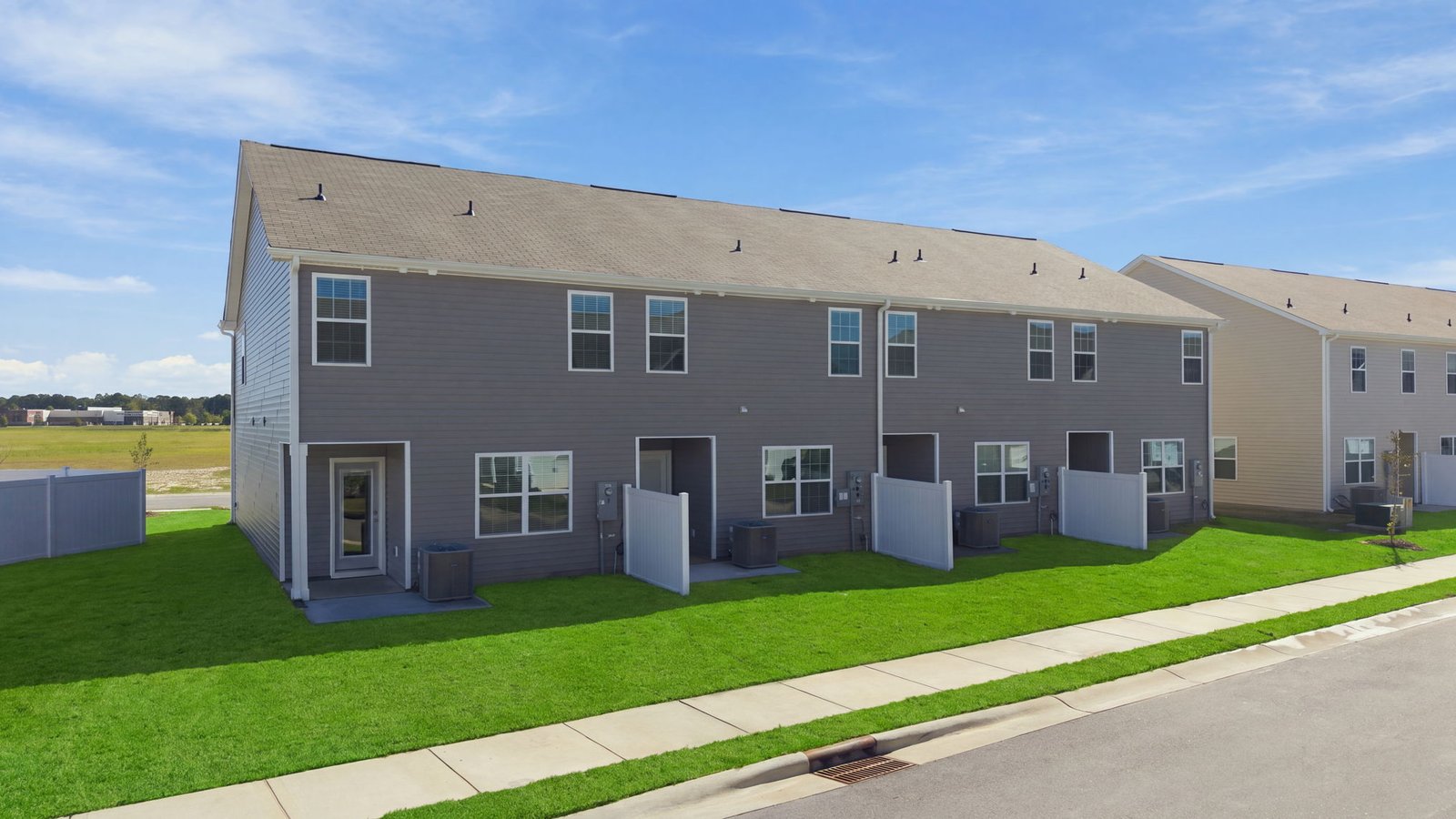 rear view of townhome and lot