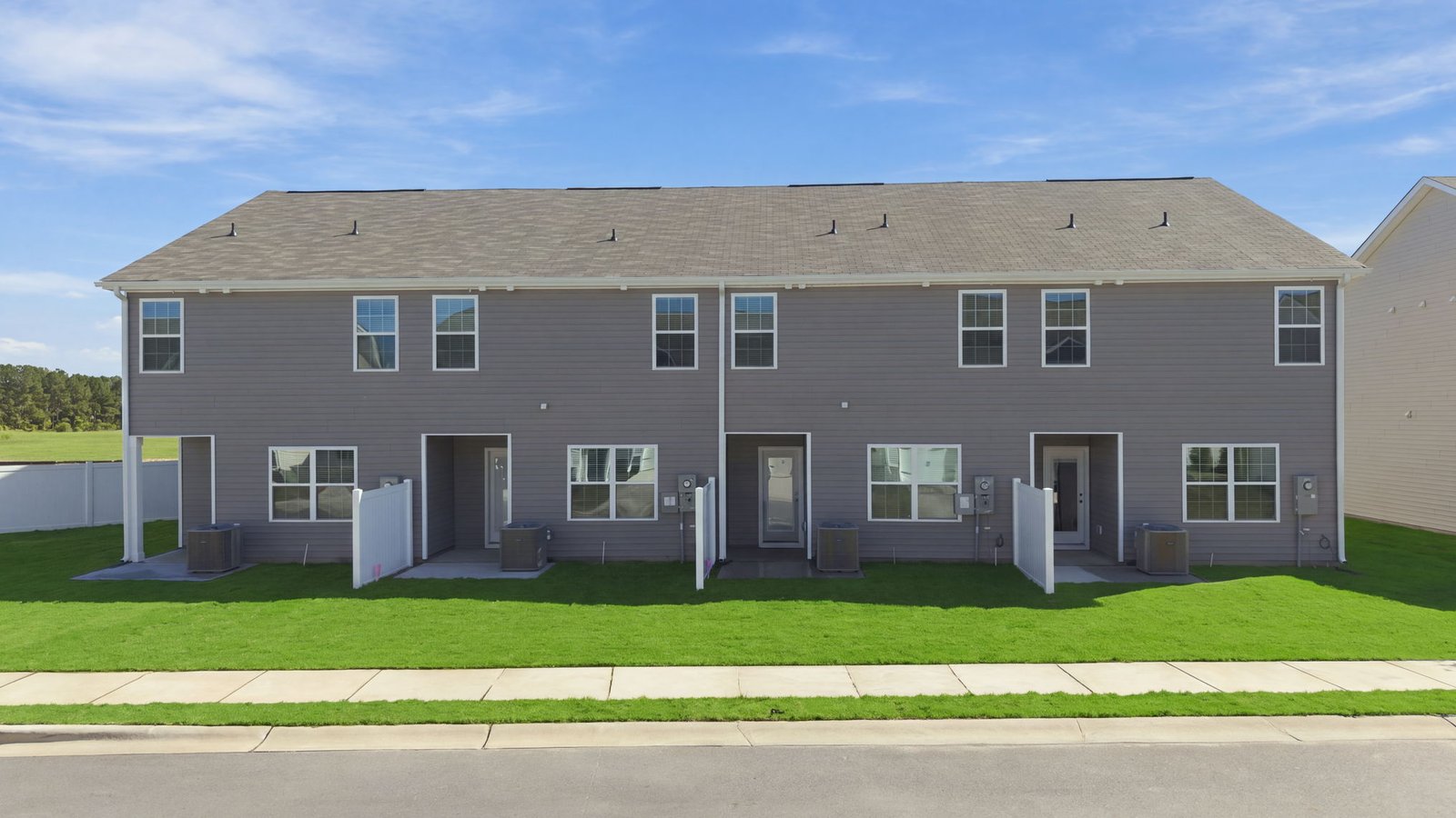 rear view of townhome and lot