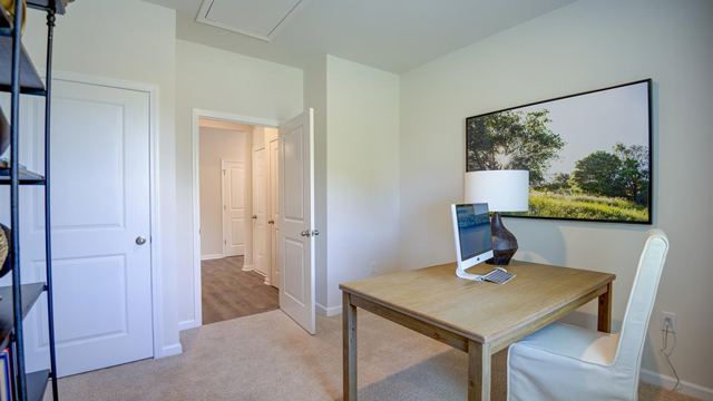 bedroom with beige carpet, white walls and a window