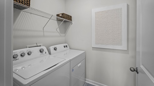 Laundry room with a washing machine and dryer with built in wire shelving