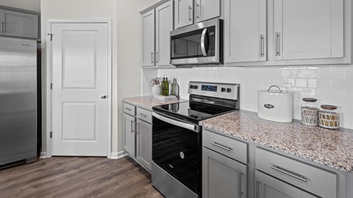 Kitchen with revwood flooring and stainless steel appliance with granite countertops and ceramic tile backsplash