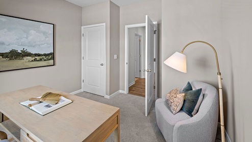Office with carpet flooring and a large window for natural light