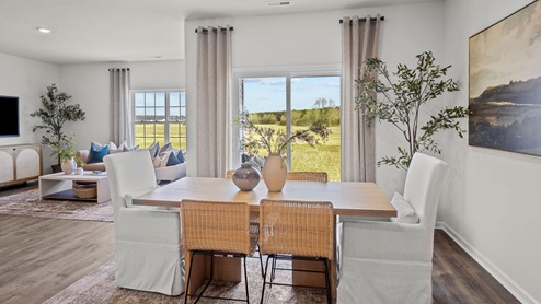 Dining area with revwood flooring and a sliding glass door leading to covered patio