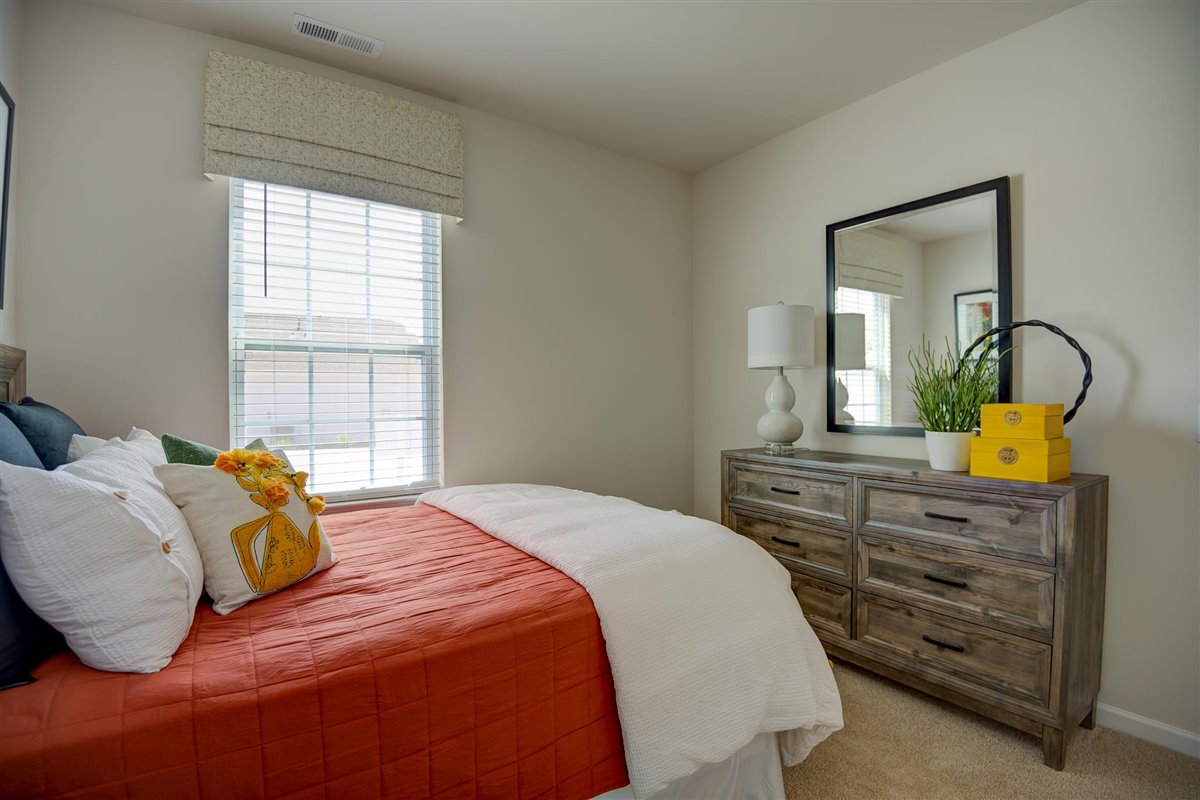 bedroom with beige carpet, beige walls and a window