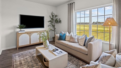 Living room with revwood flooring and a large window for natural light