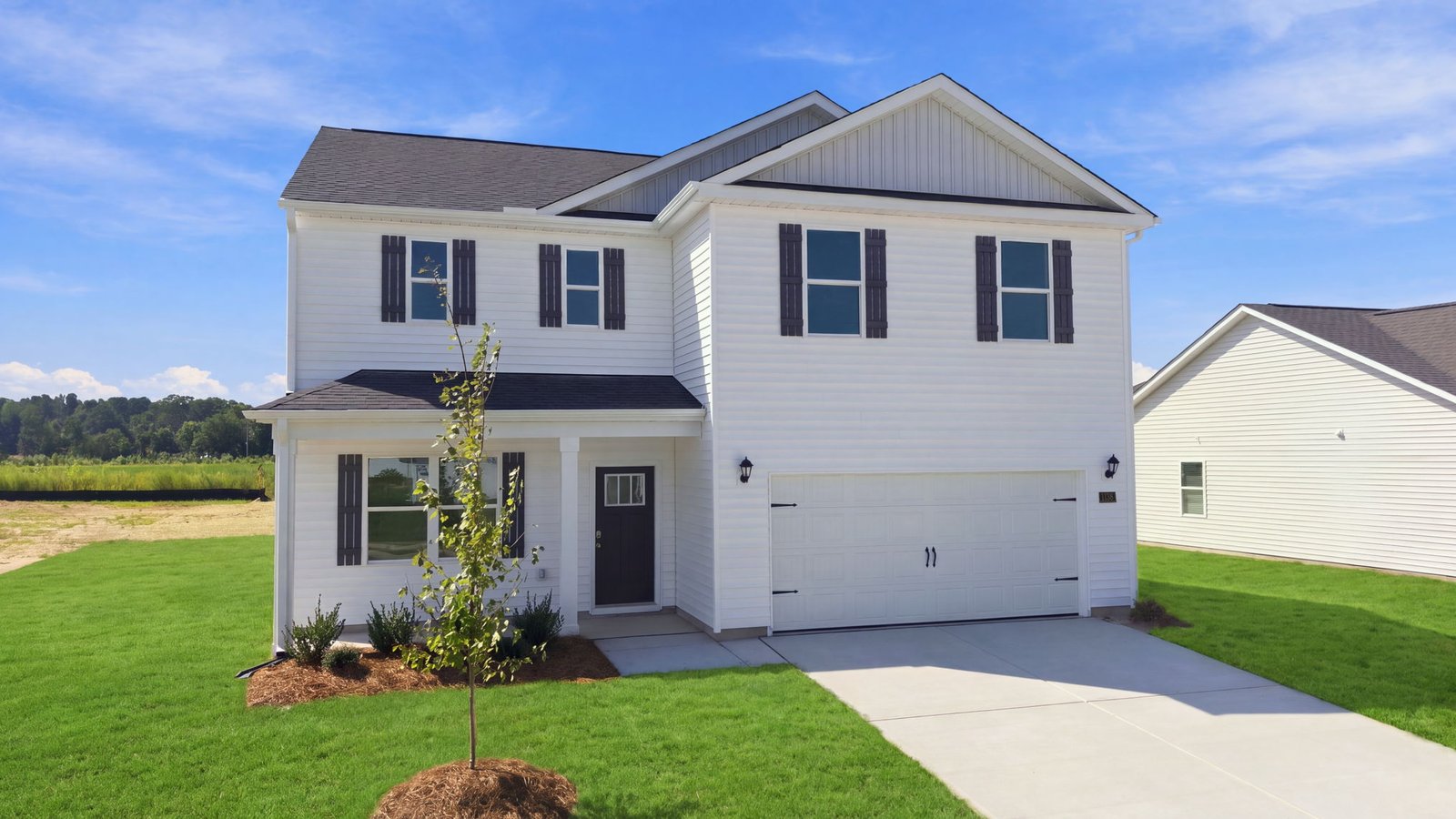 two story home with white vinyl and two car garage