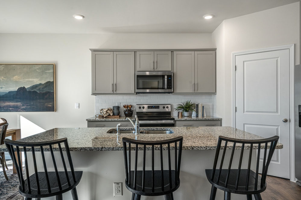 kitchen with light grey cabinetry, large island and stainless steel appliances