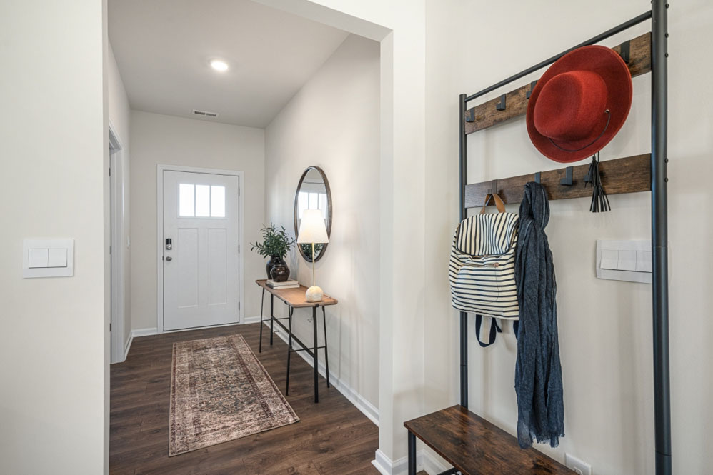 front entry way of home featuring brown flooring and white walls