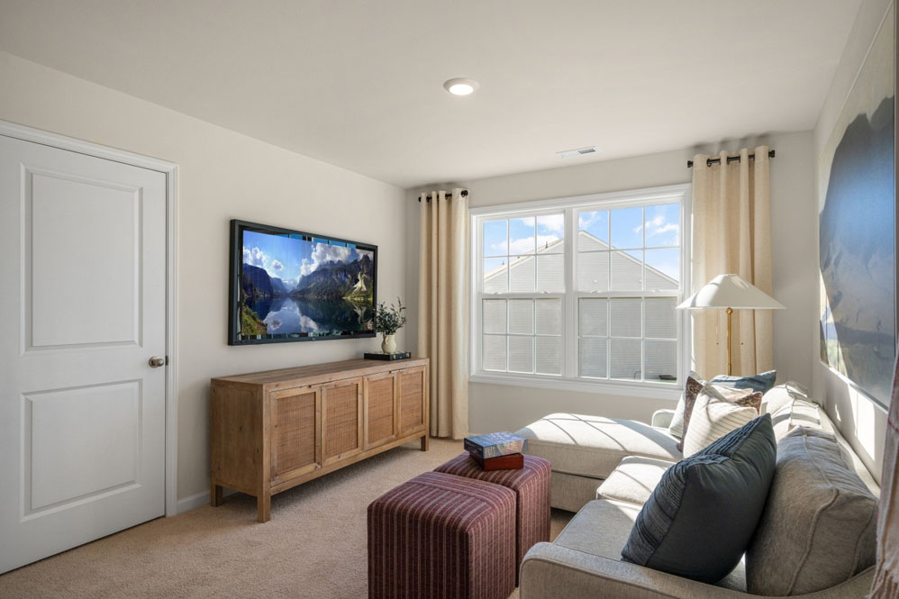 bedroom with beige carpet, white walls and a window