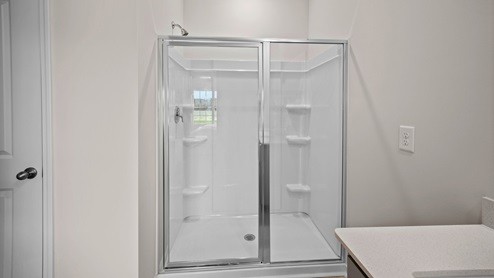 Primary bathroom with quartz countertops and a walk in shower