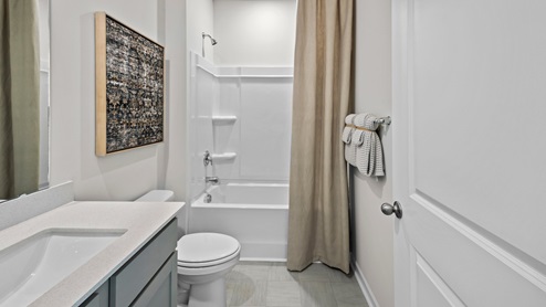 Bathroom with quartz countertop and a bathtub